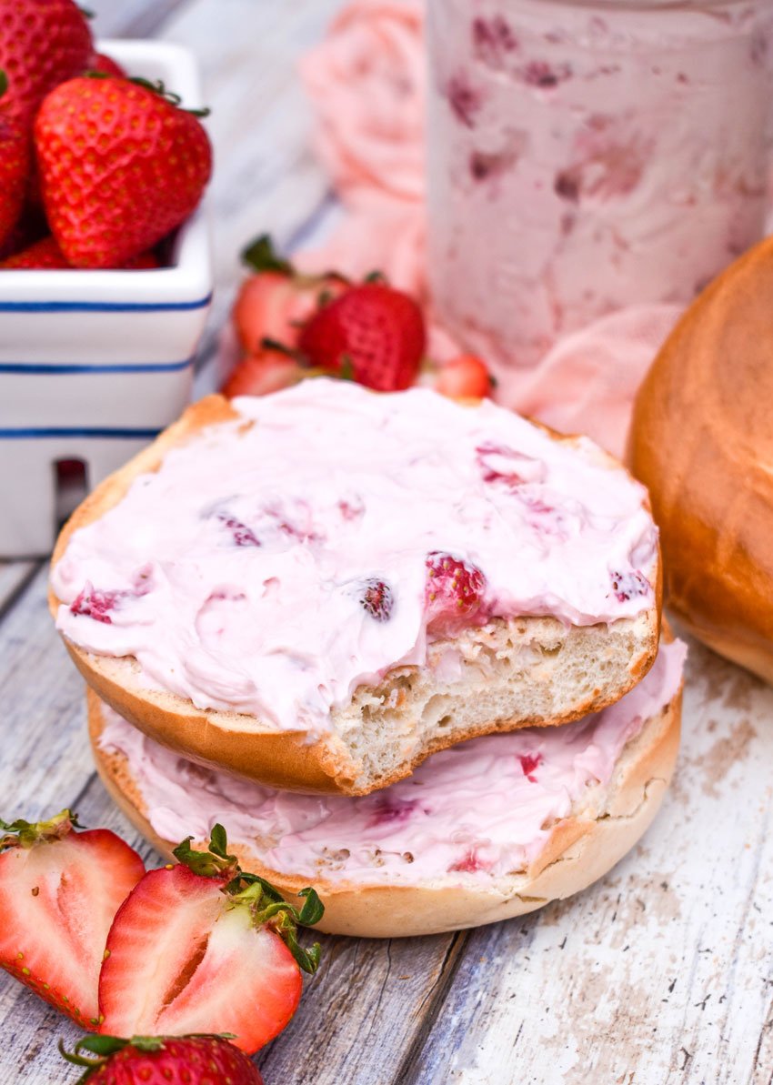 a bitten bagel topped with easy homemade strawberry cream cheese spread