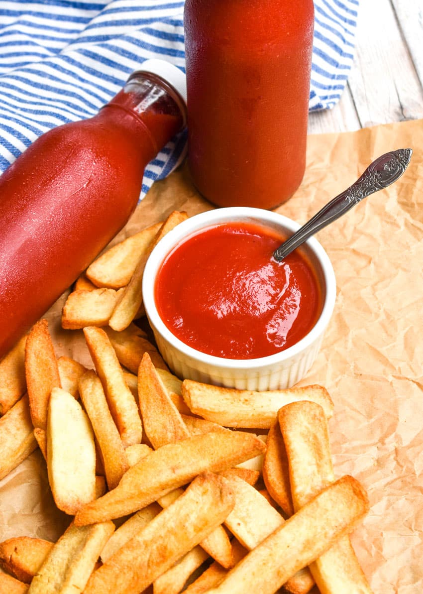slow cooker ketchup in a small white bowl with a spoon