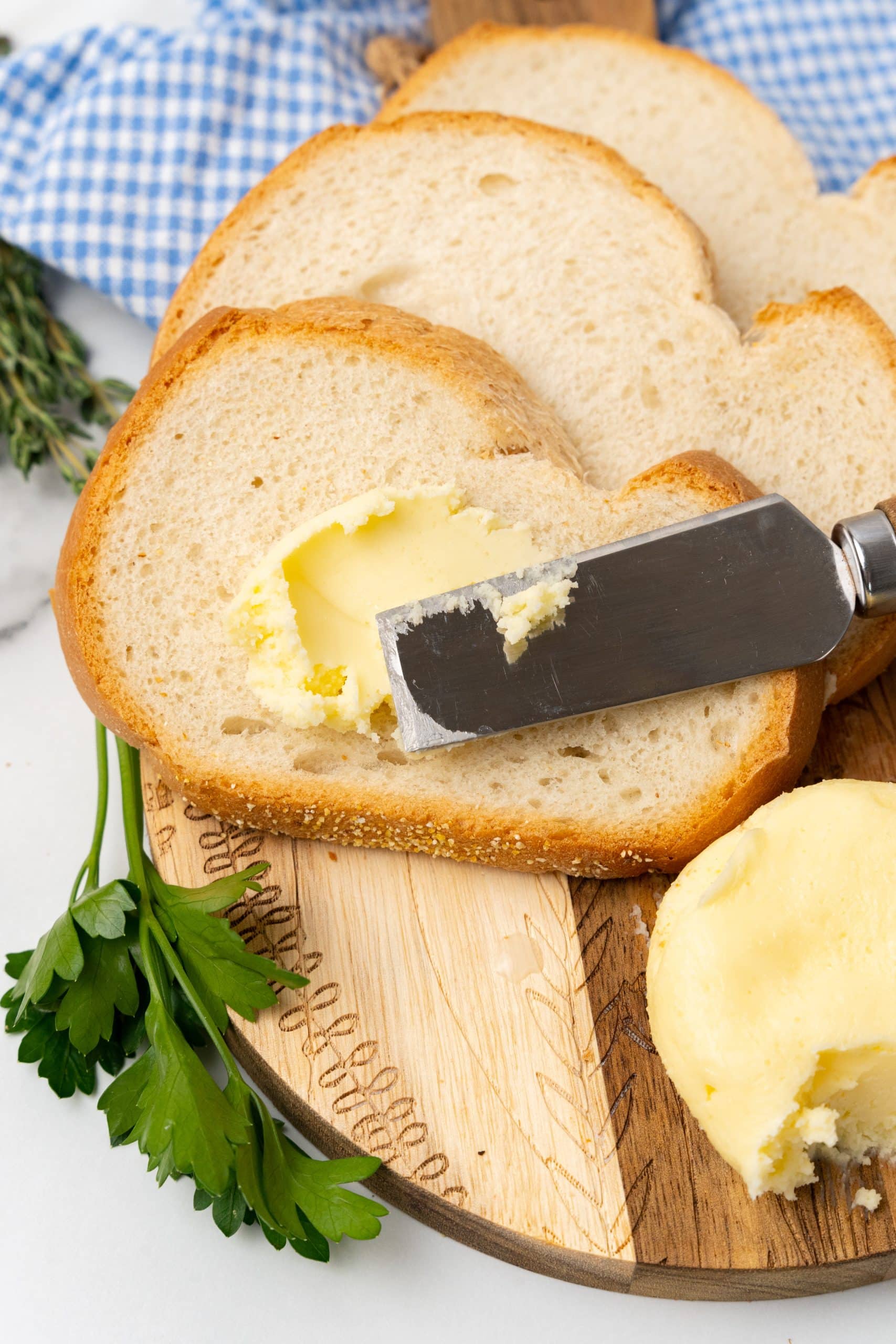 fresh homemade butter being spread on a soft slice of white bread