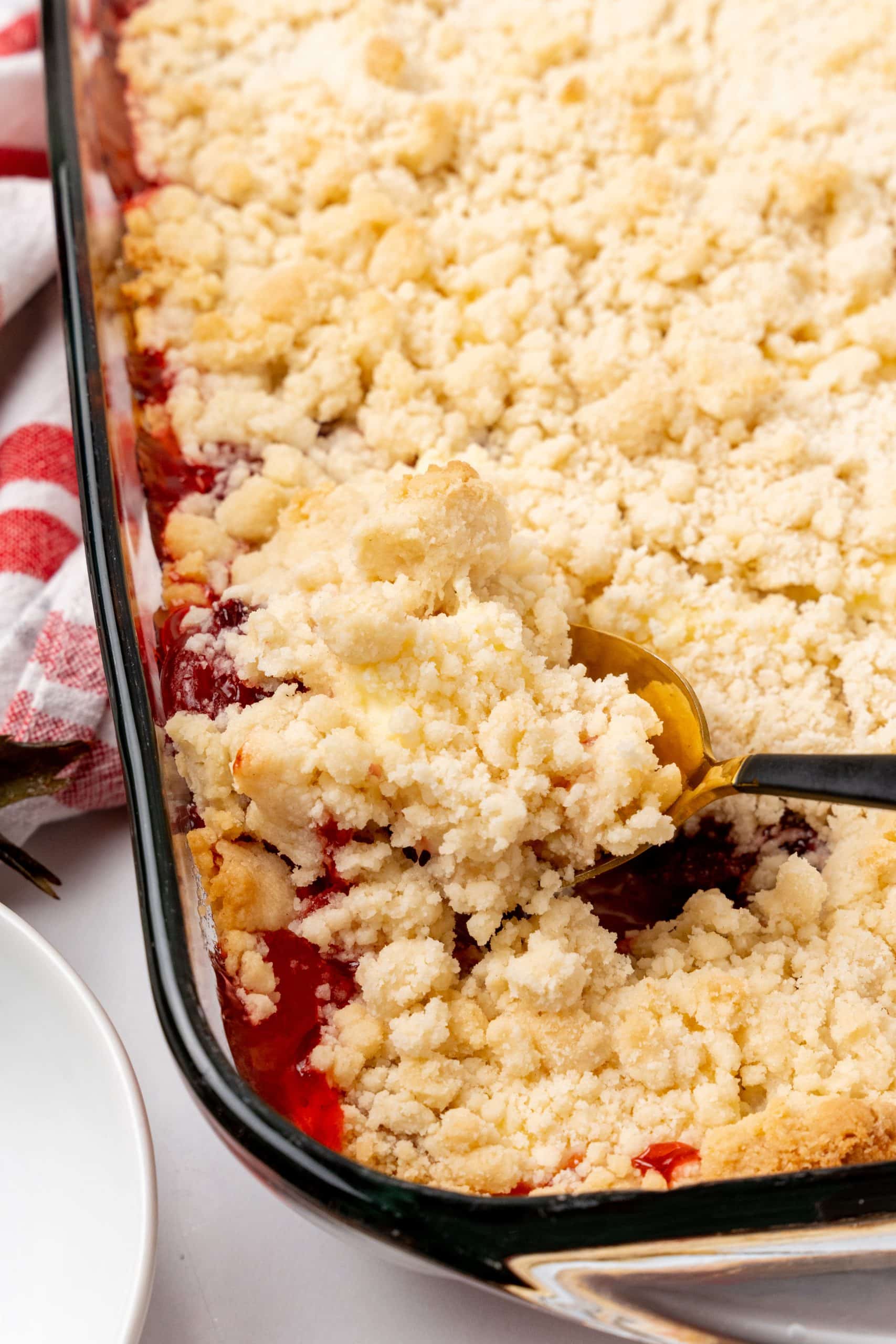 a spoon digging in to a baked strawberry dump cake