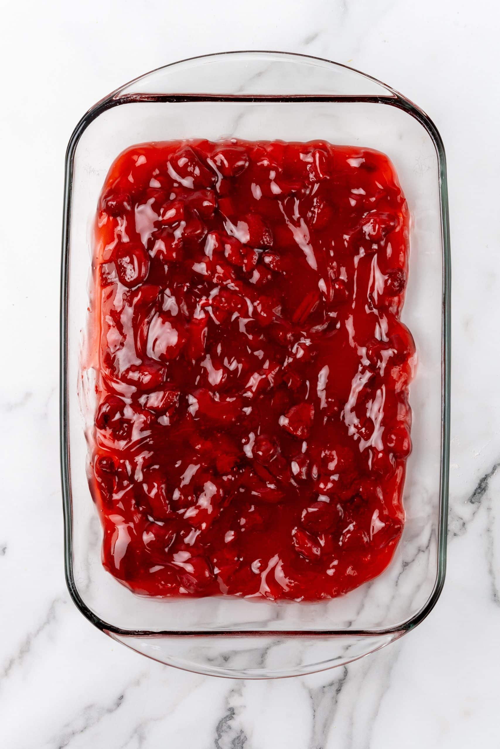 strawberry pie filling spread in a large glass baking dish