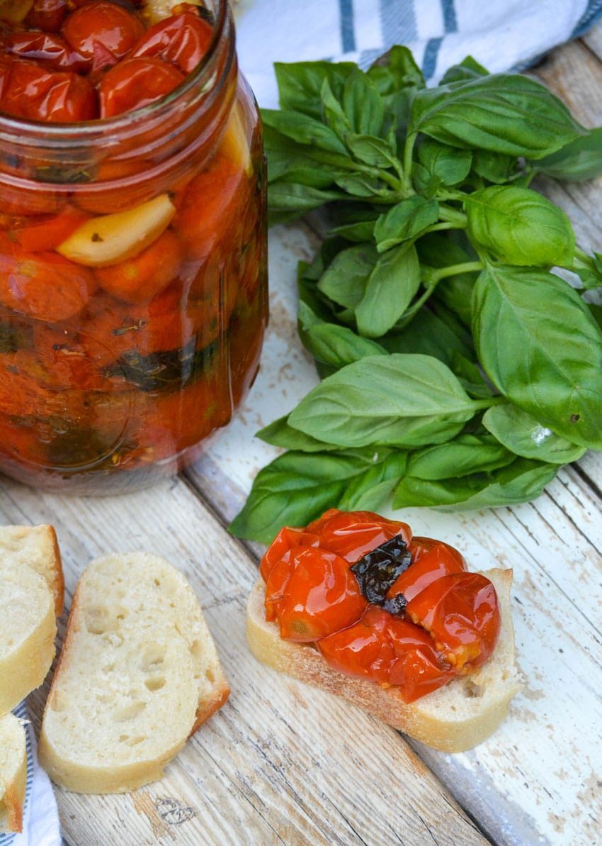 quick tomato confit recipe spread on a slice of baguette