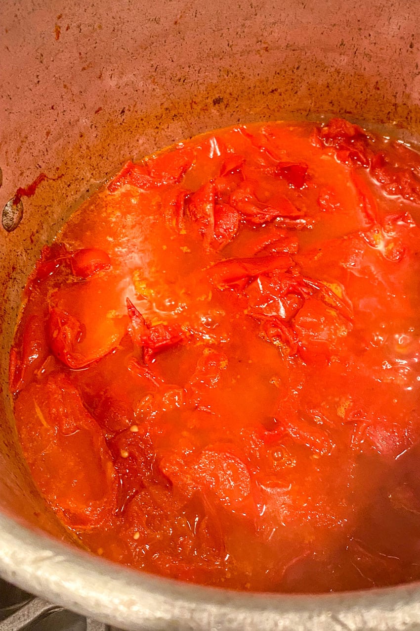 fresh tomatoes cooking down in a large stockpot