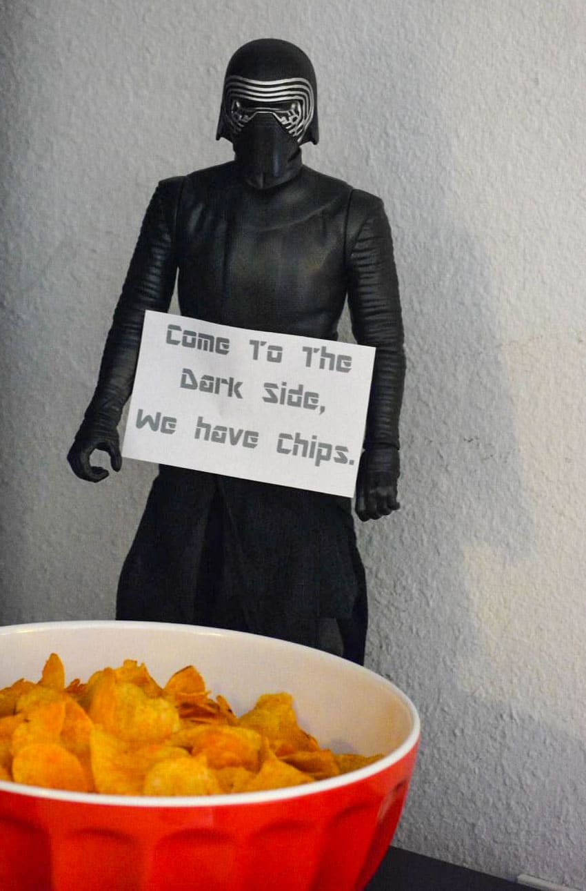 a star wars figure as a sign holder on a snack table at a birthday party