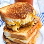 the best grilled cheese sandwiches stacked on a white plate