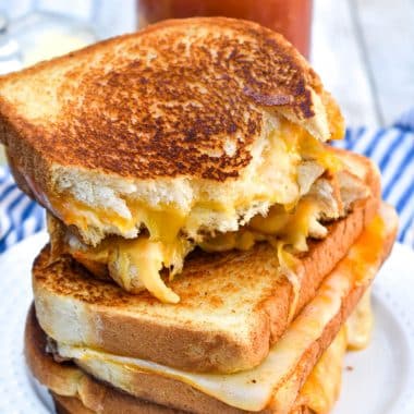 the best grilled cheese sandwiches stacked on a white plate