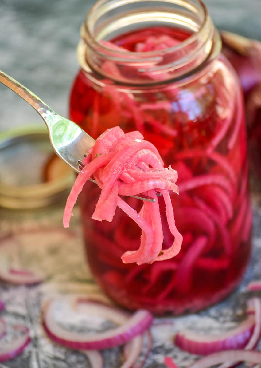 pickled red onions on a silver fork