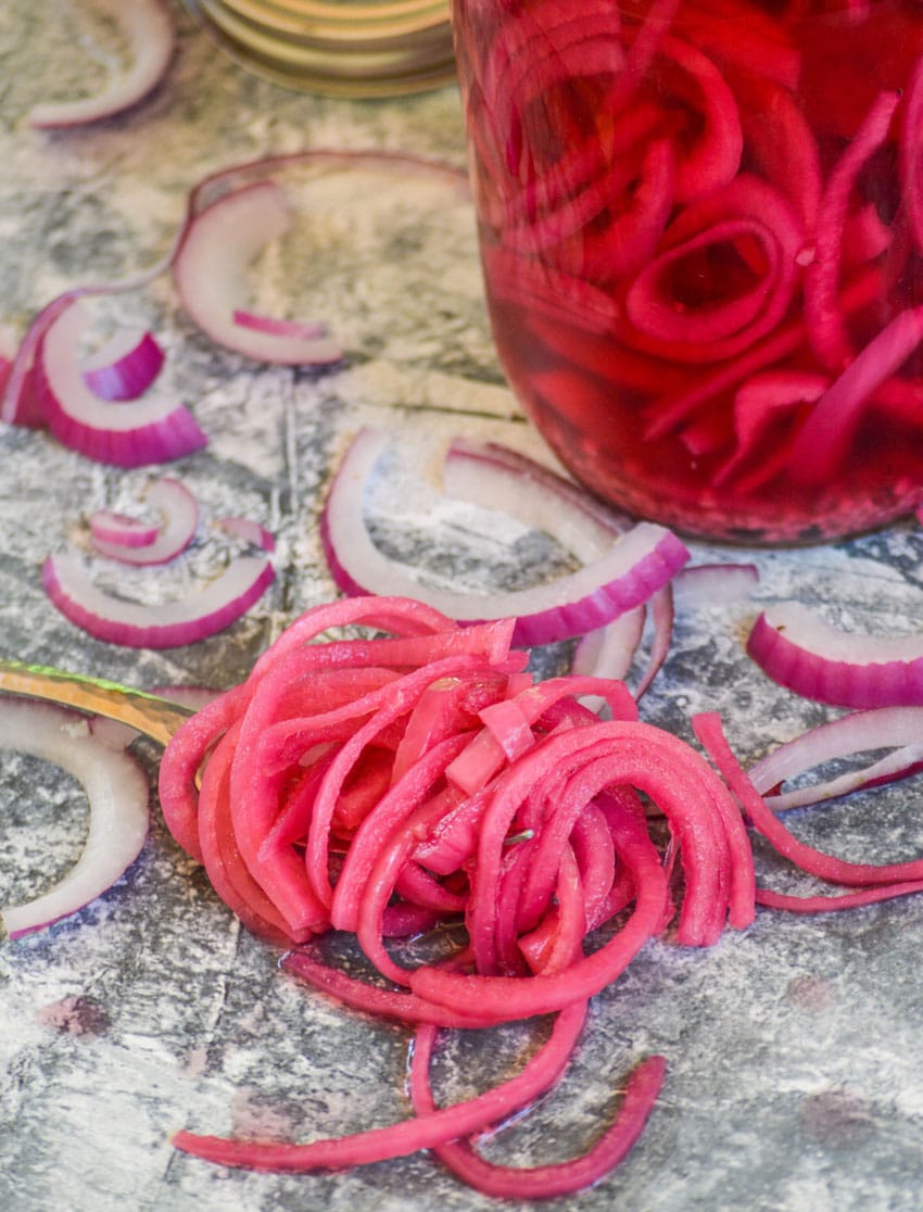 a pile of quick pickled onions on a marbled counter