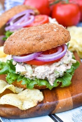 smoked chicken salad on a fluffy wheat bun sitting on a wooden cutting board