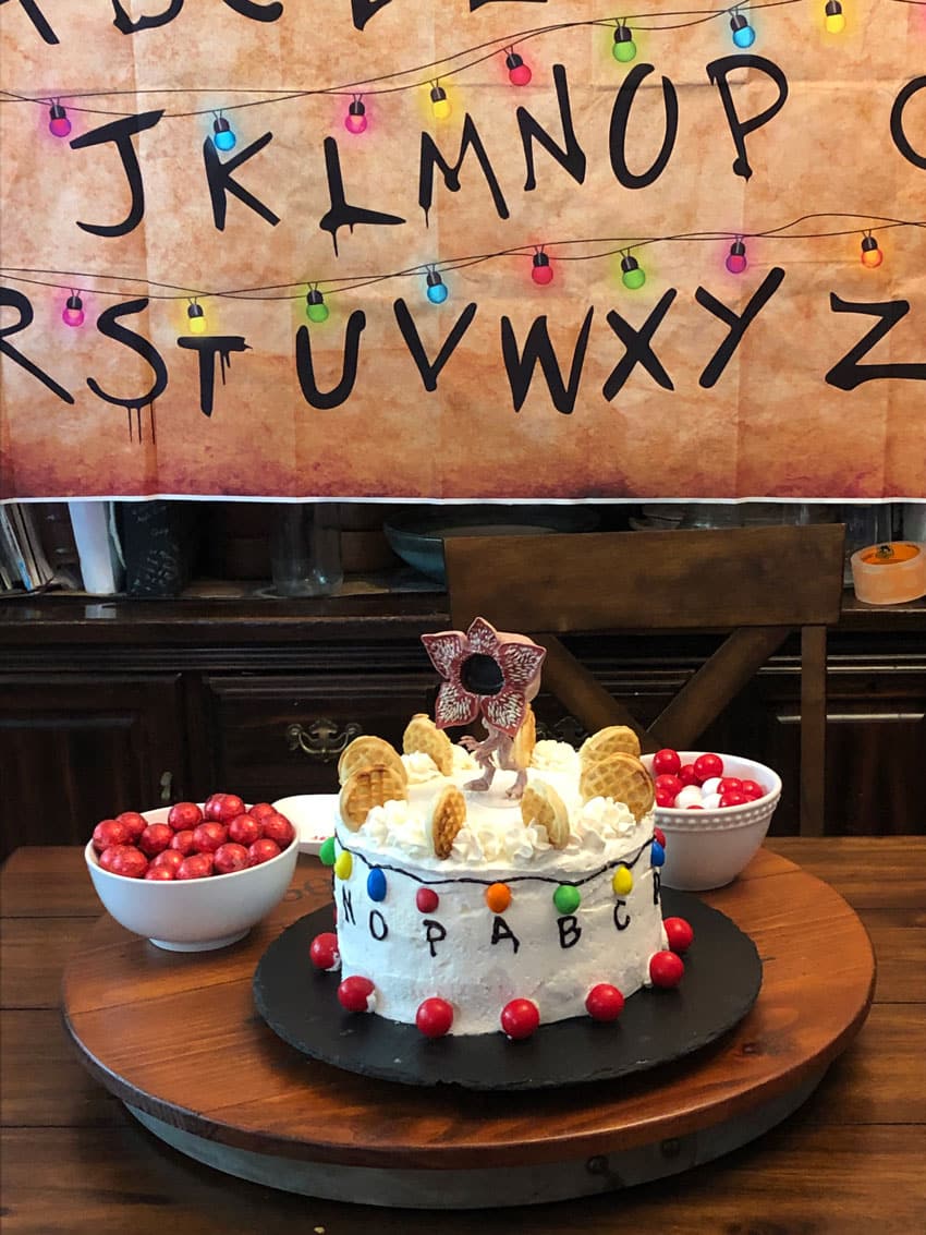 stranger things christmas light and alphabet vinyl banner hung above a cake table