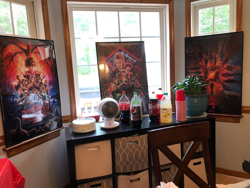 framed stranger things season image posters above a drink station
