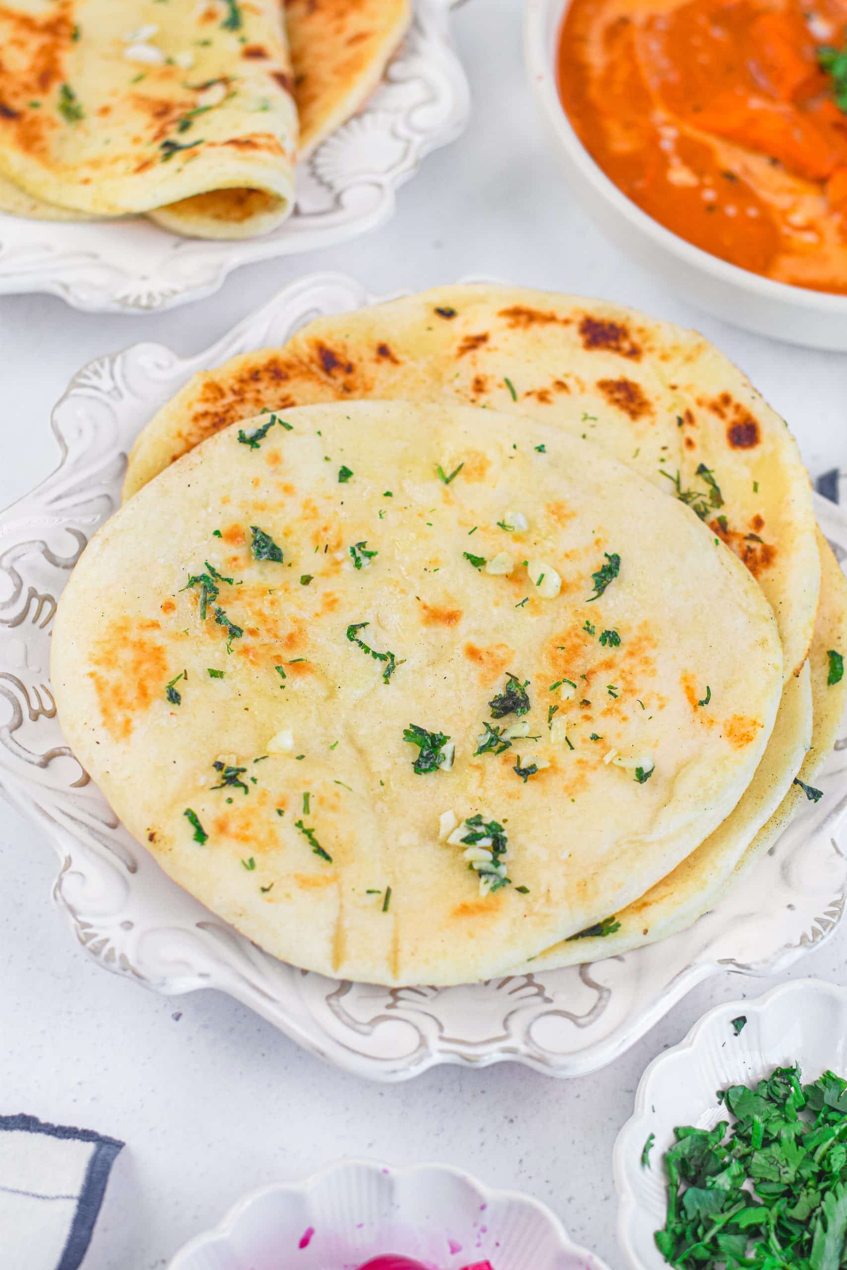 slices of toasted garlic naan bread piled on a white plate