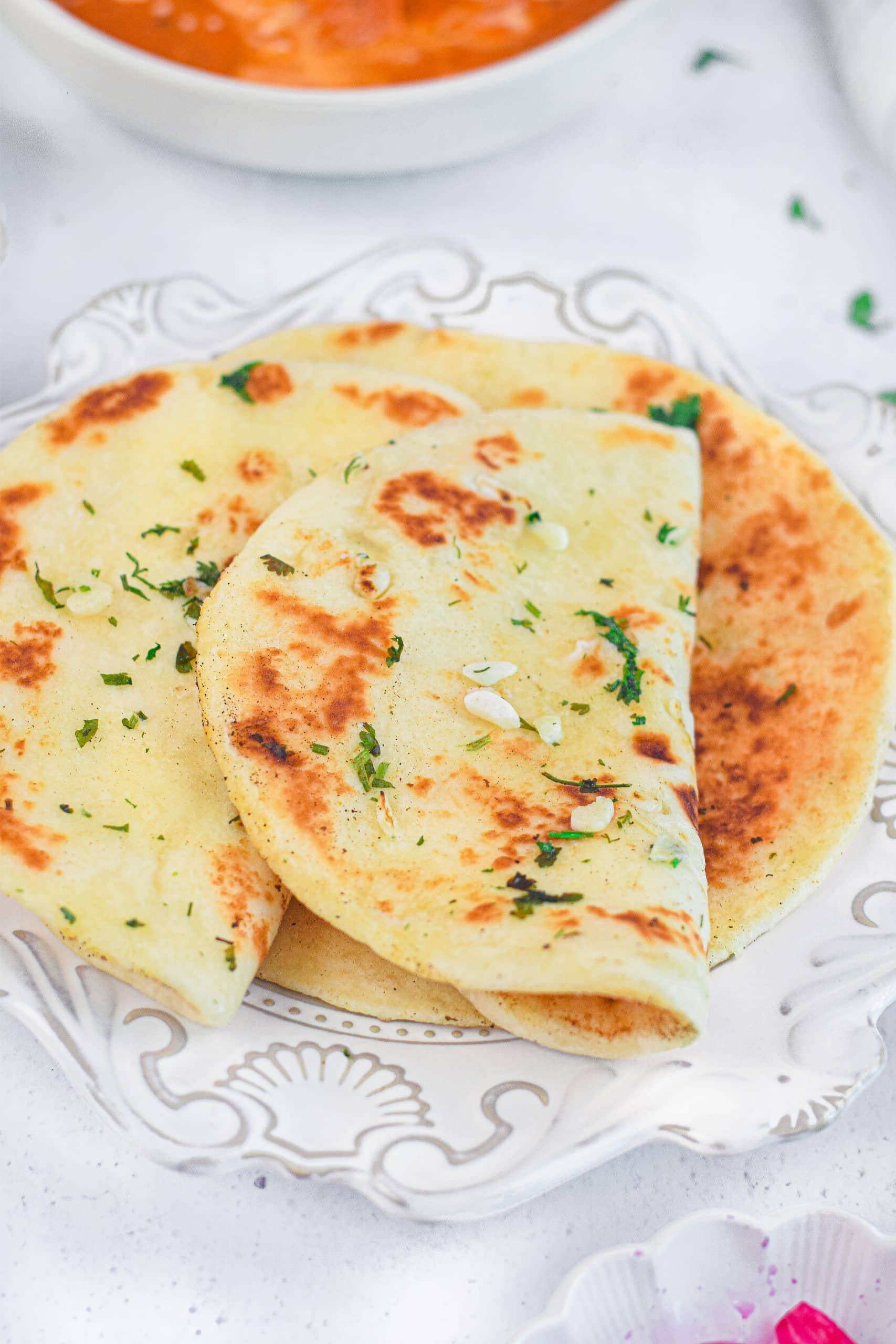 folded pieces of air fryer naan bread on a white plate