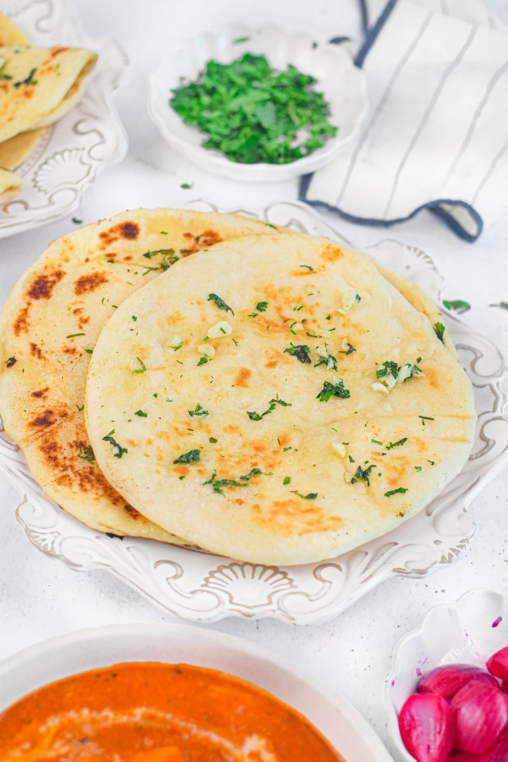 slices of toasted garlic naan bread piled on a white plate