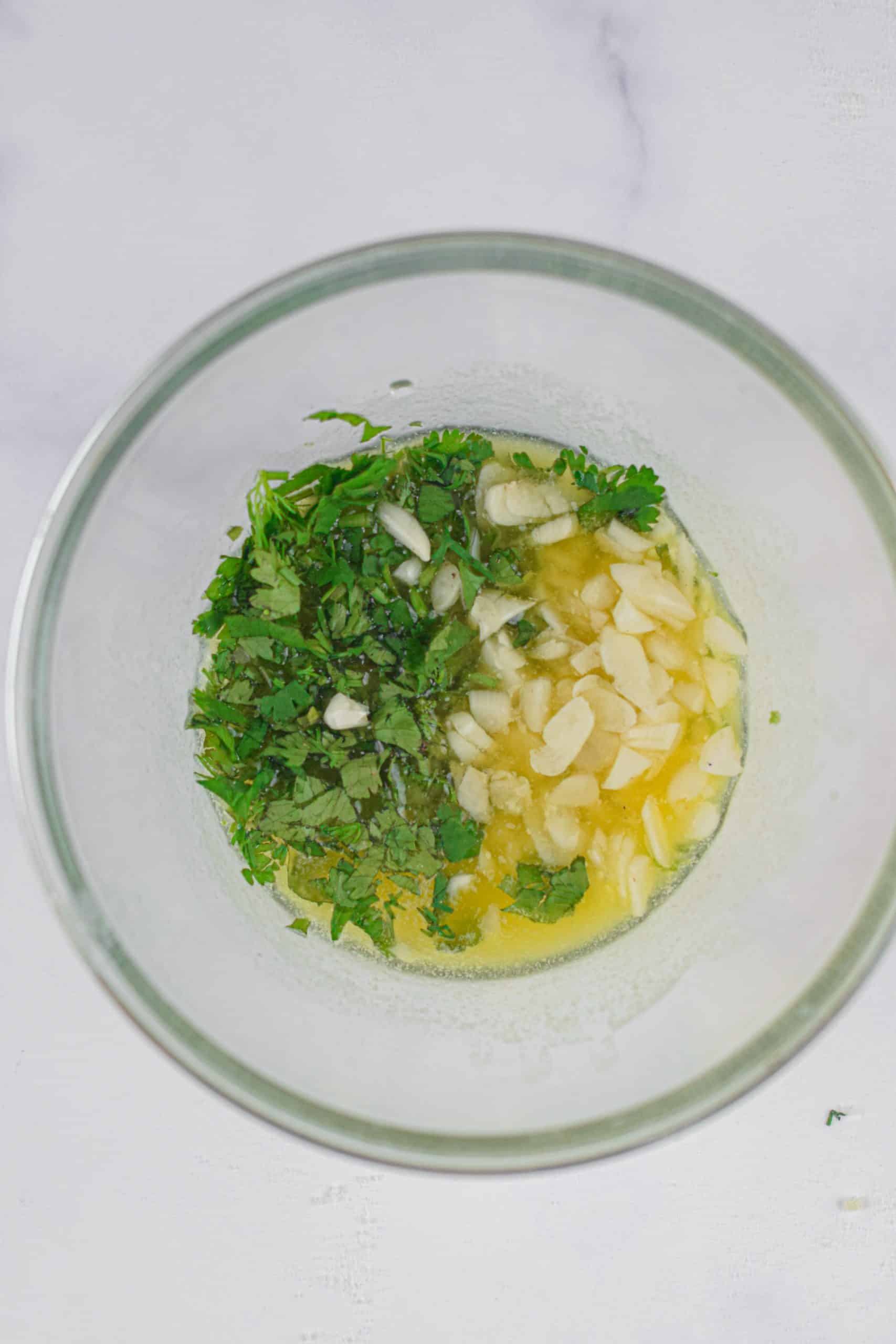 garlic, butter, and herbs in a small glass bowl