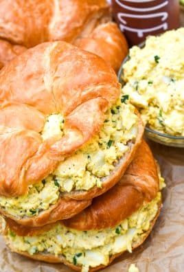 smoked egg salad on croissant rolls stacked on top of each other