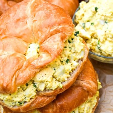 smoked egg salad on croissant rolls stacked on top of each other