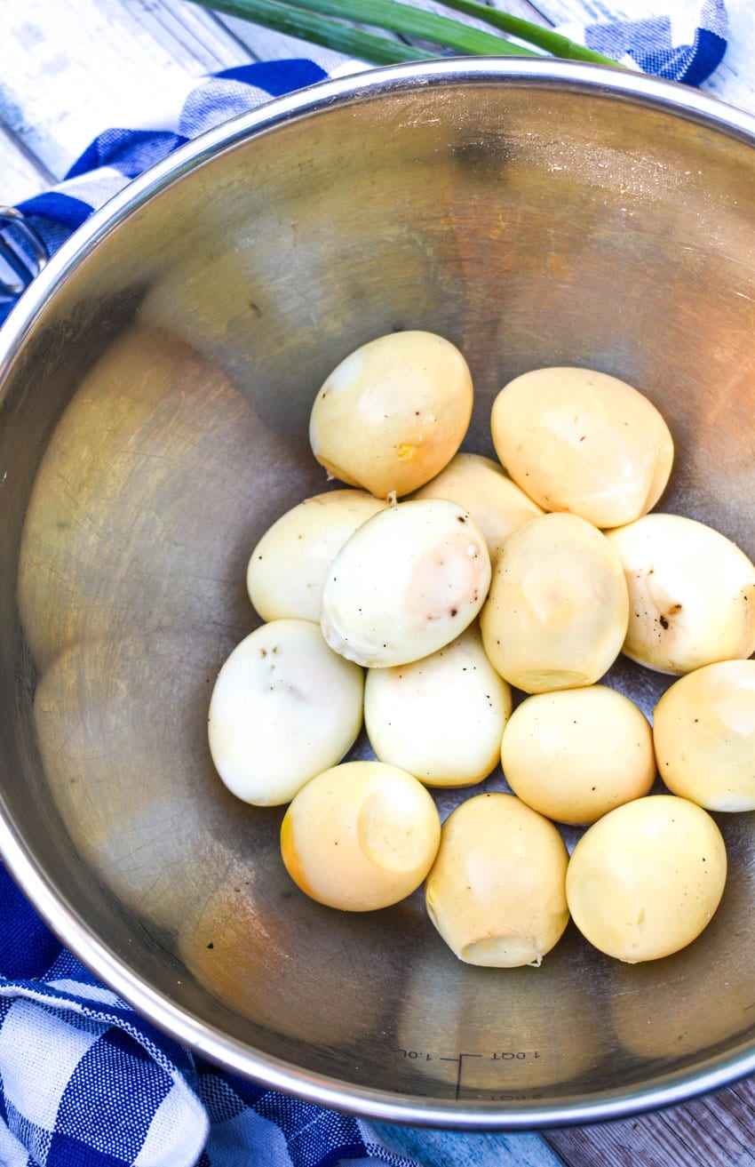 peeled smoked hard boiled eggs in a large metal mixing bowl