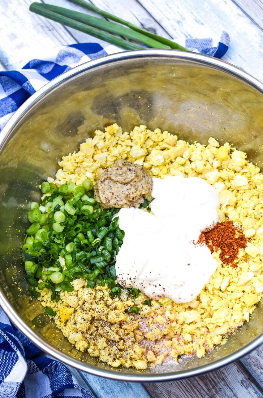 an overhead image showing the measured ingredients for smoked egg salad in a large metal mixing bowl