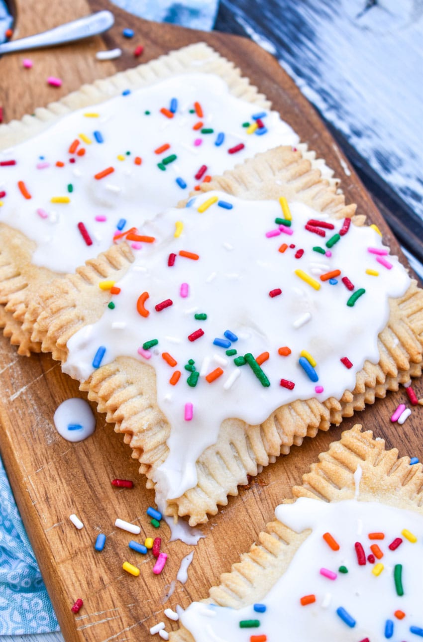 Air Fryer Strawberry Pop Tarts stacked on a wooden cutting board