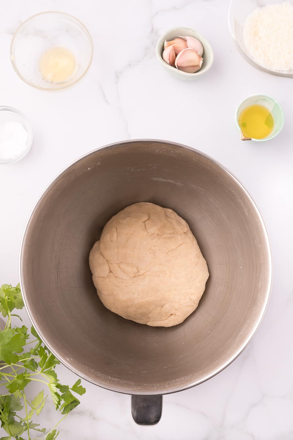 garlic knot dough ball in the metal bowl of a stand mixer