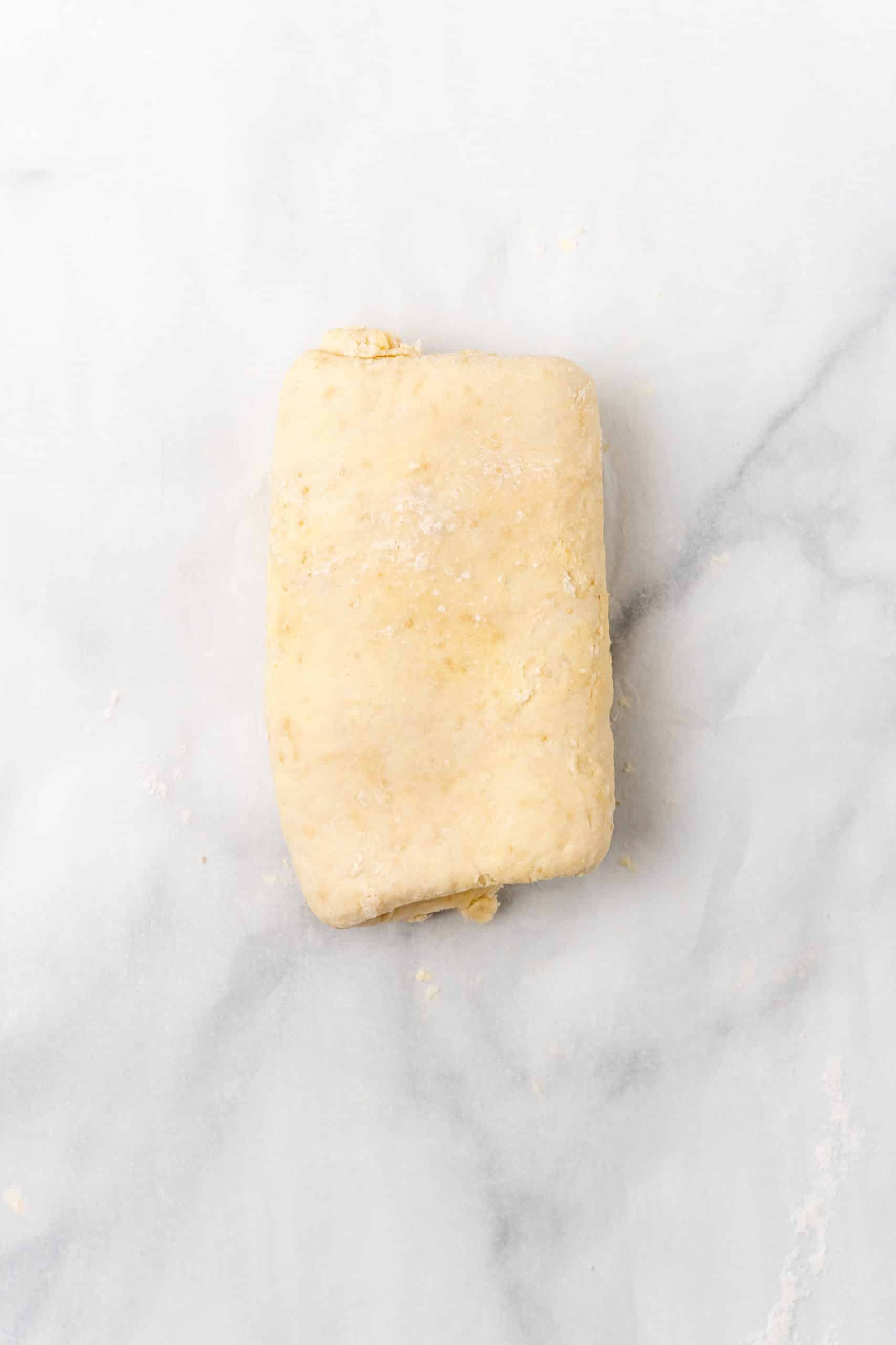 the perfect buttery homemade croissant dough resting on a marble countertop