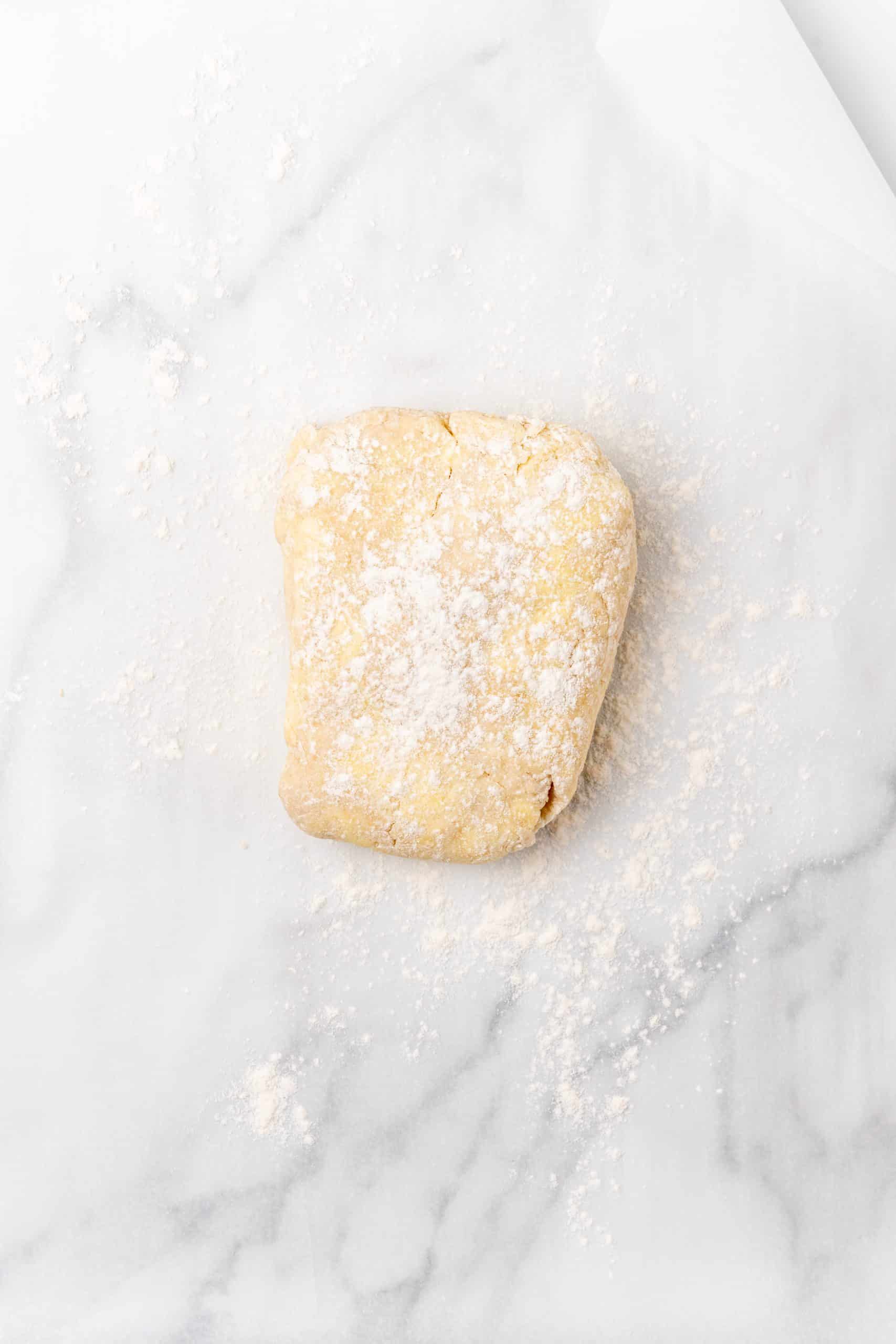 floured butter croissant dough on a kitchen counter
