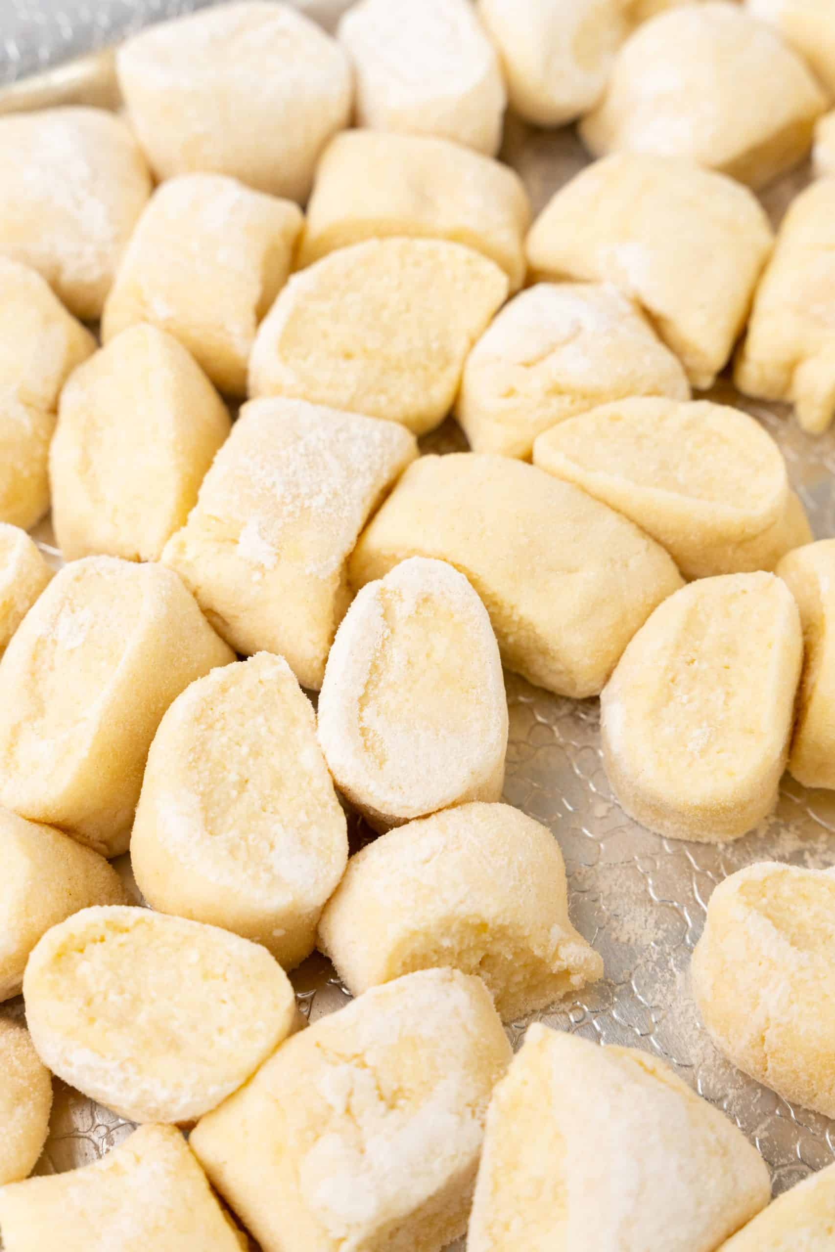 1/2 inch pieces of 20 minute ricotta gnocchi on a floured sheet pan