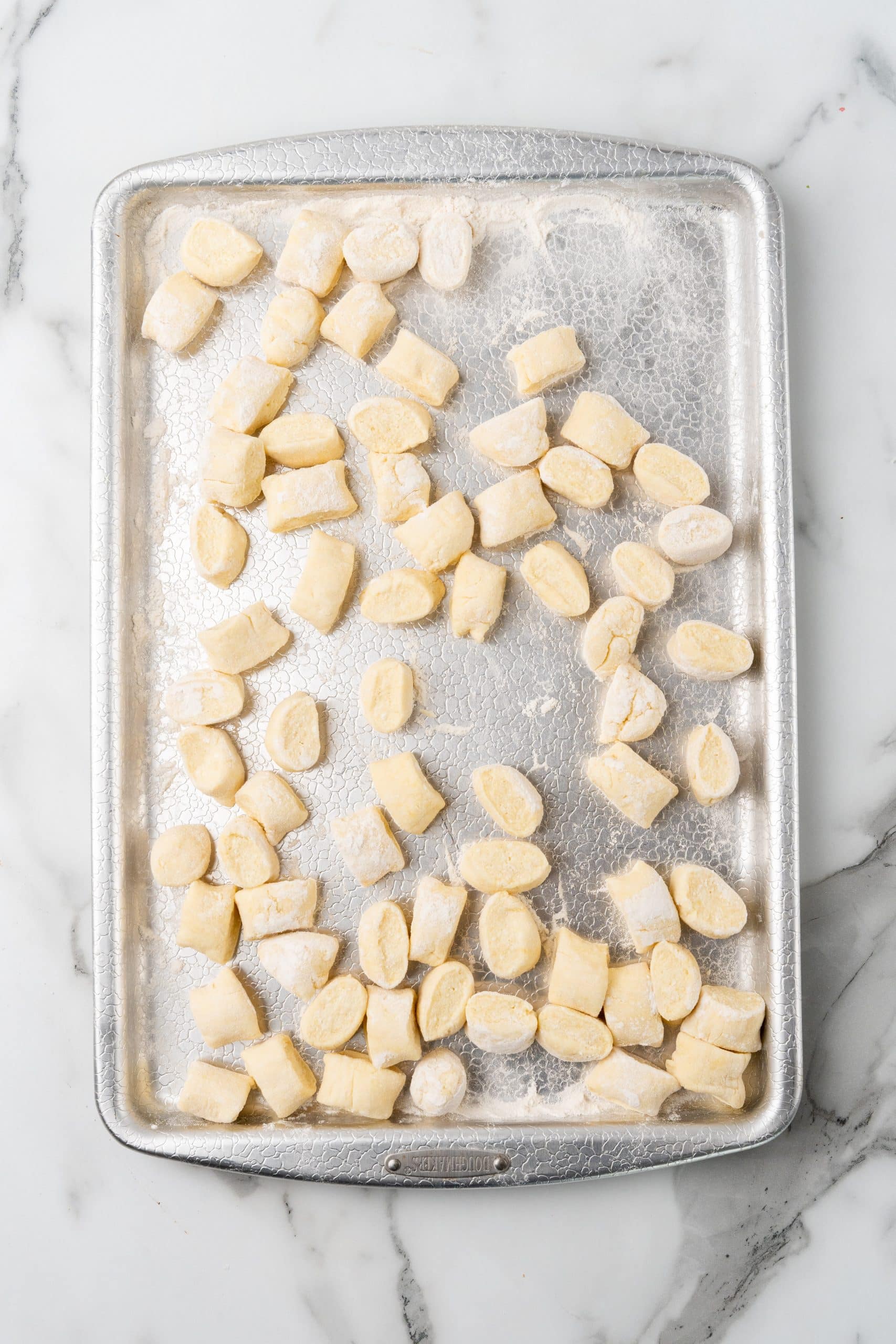 cut pieces of homemade gnocchi on a floured sheet pan