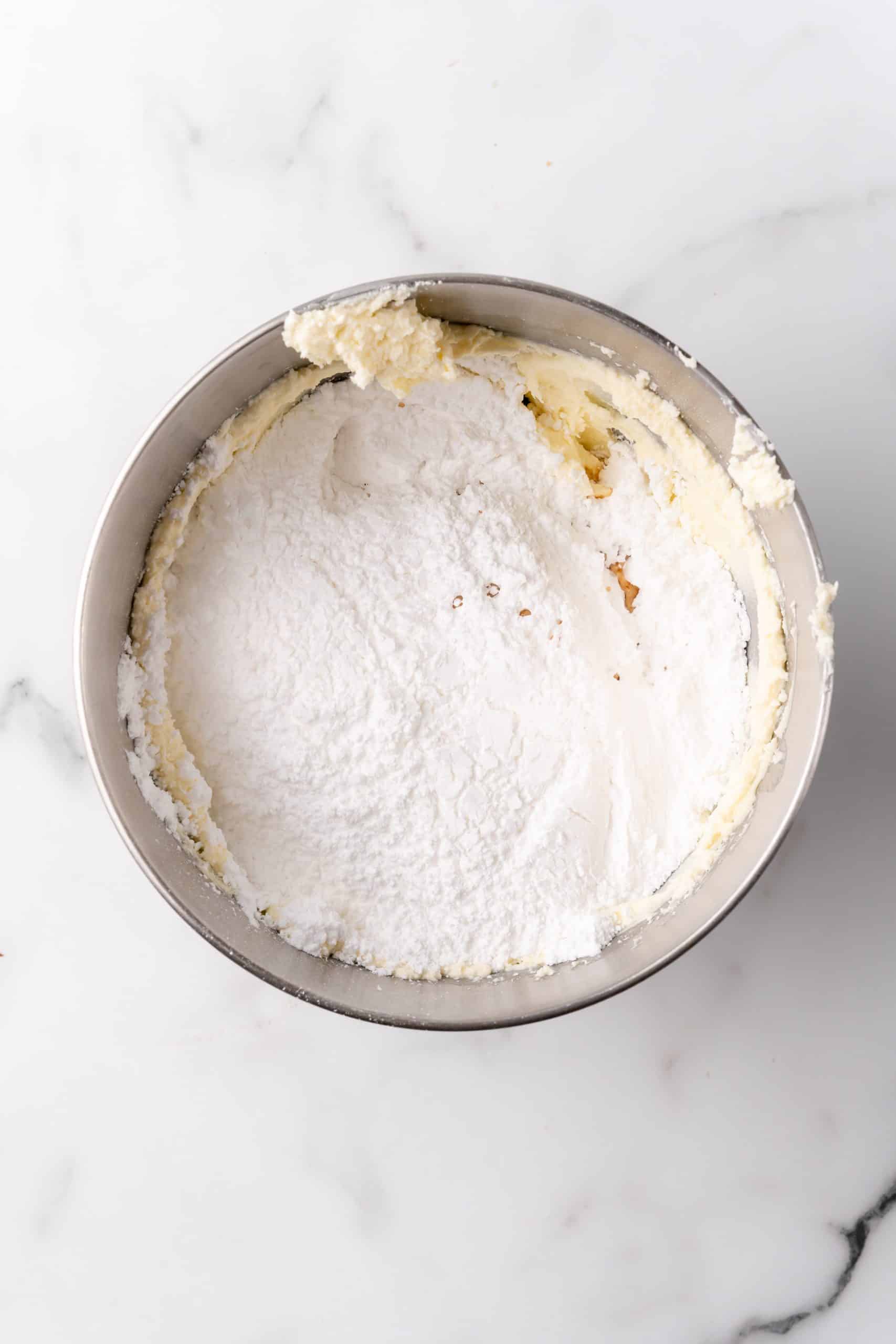 powdered sugar in a mixing bowl with whipped butter