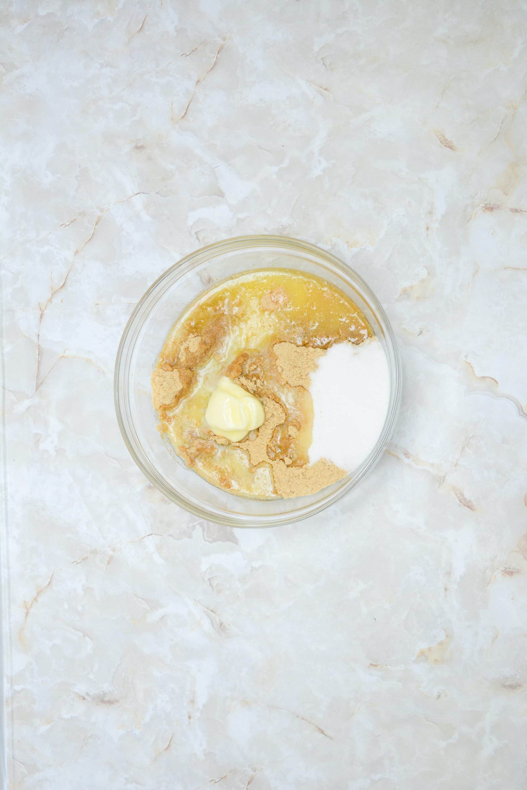 graham cracker crumbs and melted butter in a glass mixing bowl