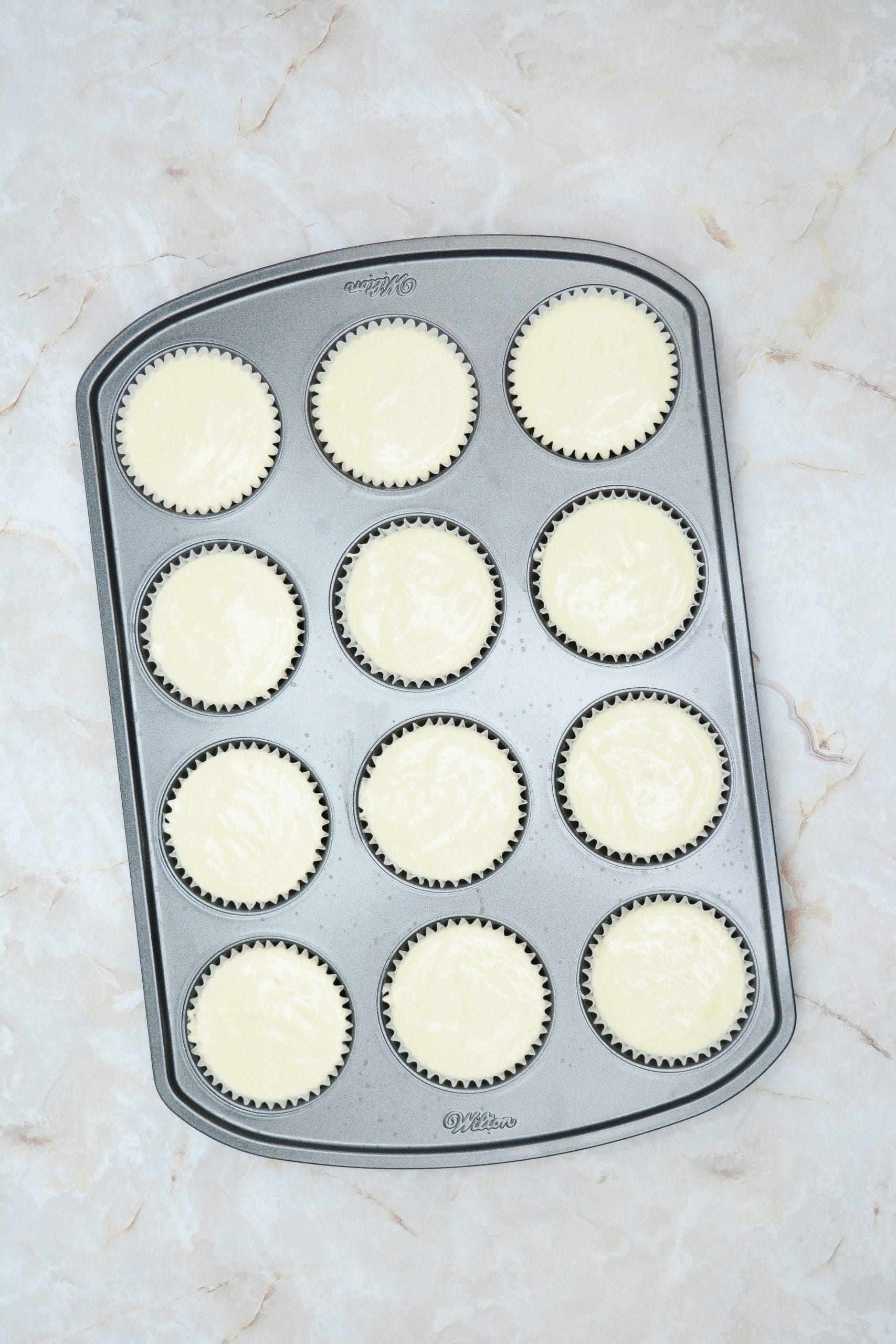 unbaked mini cheesecakes in a cupcake tin