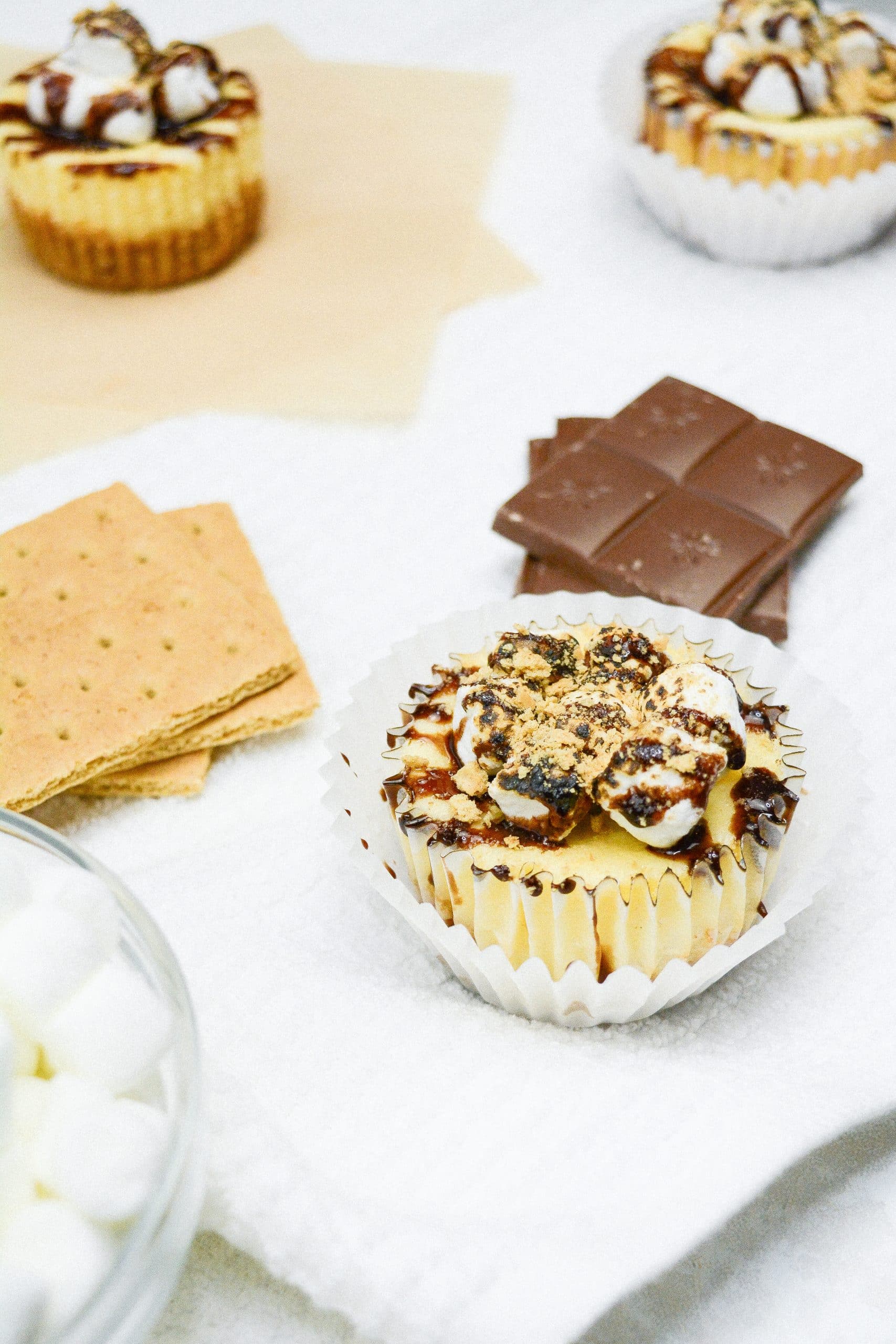 Mini s'mores cheesecakes on a wooden cake stand