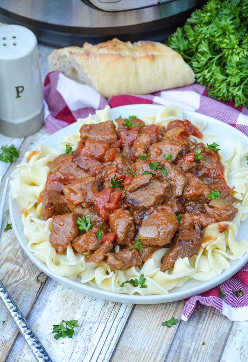Instant Pot Hungarian goulash over egg noodles on a white plate