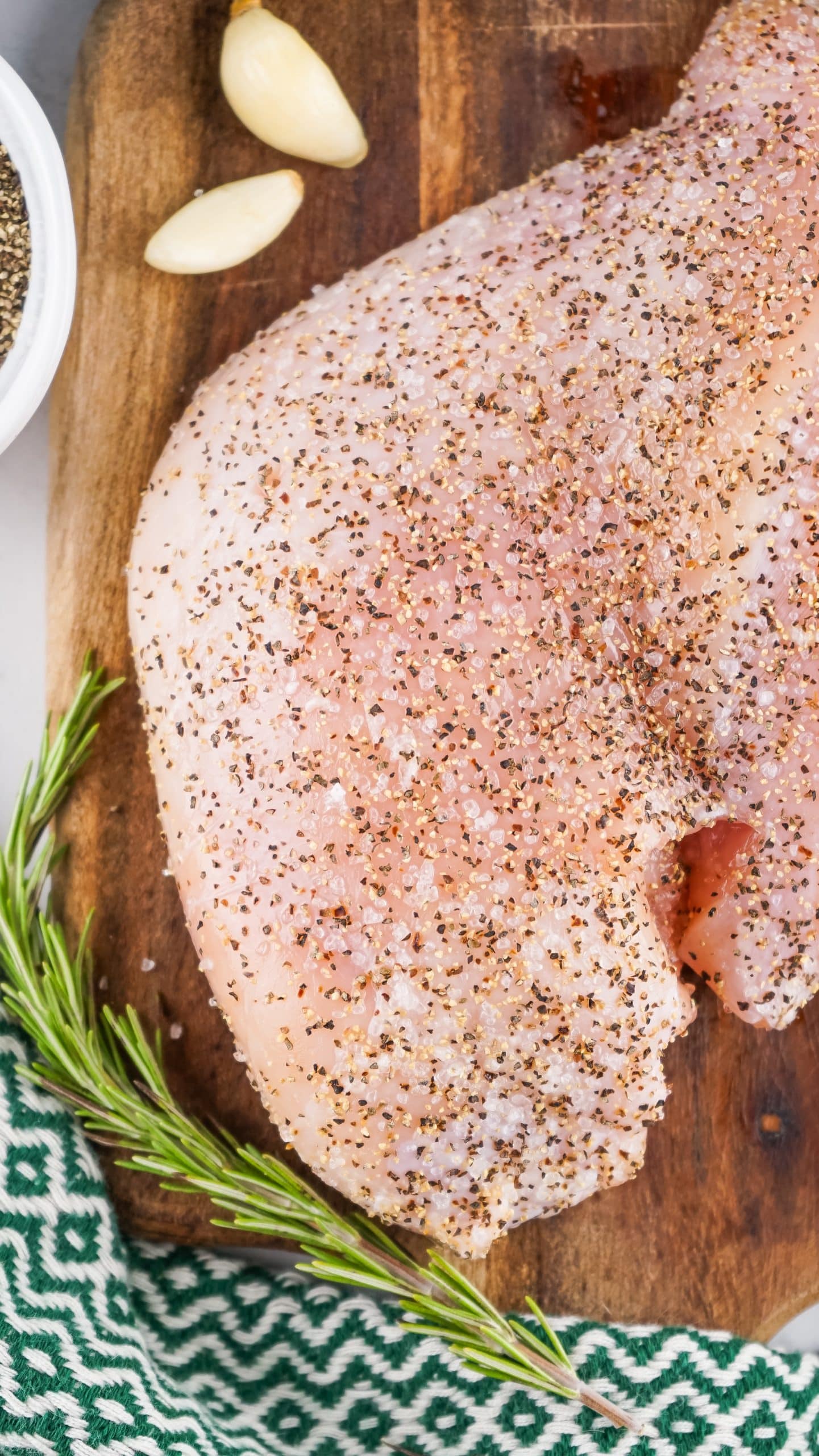 salt and pepper covered turkey breast on a wooden cutting board
