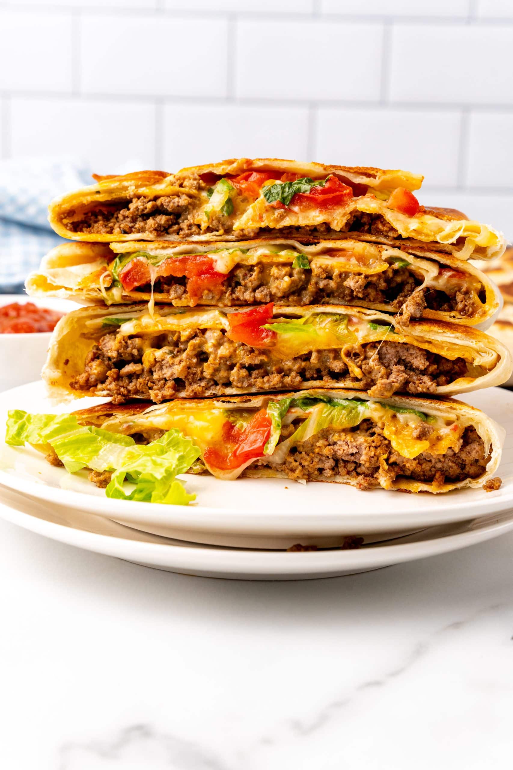 copycat crunchwrap supremes stacked on a white plate