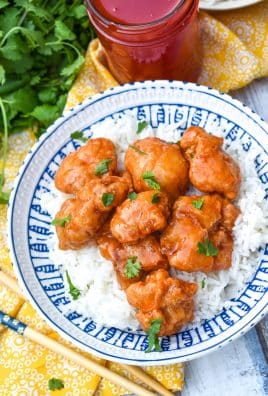 easy sweet and sour chicken over steamed white rice in a white and blue bowl