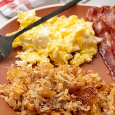 easy homemade hash browns on a brown plate with a side of eggs and bacon