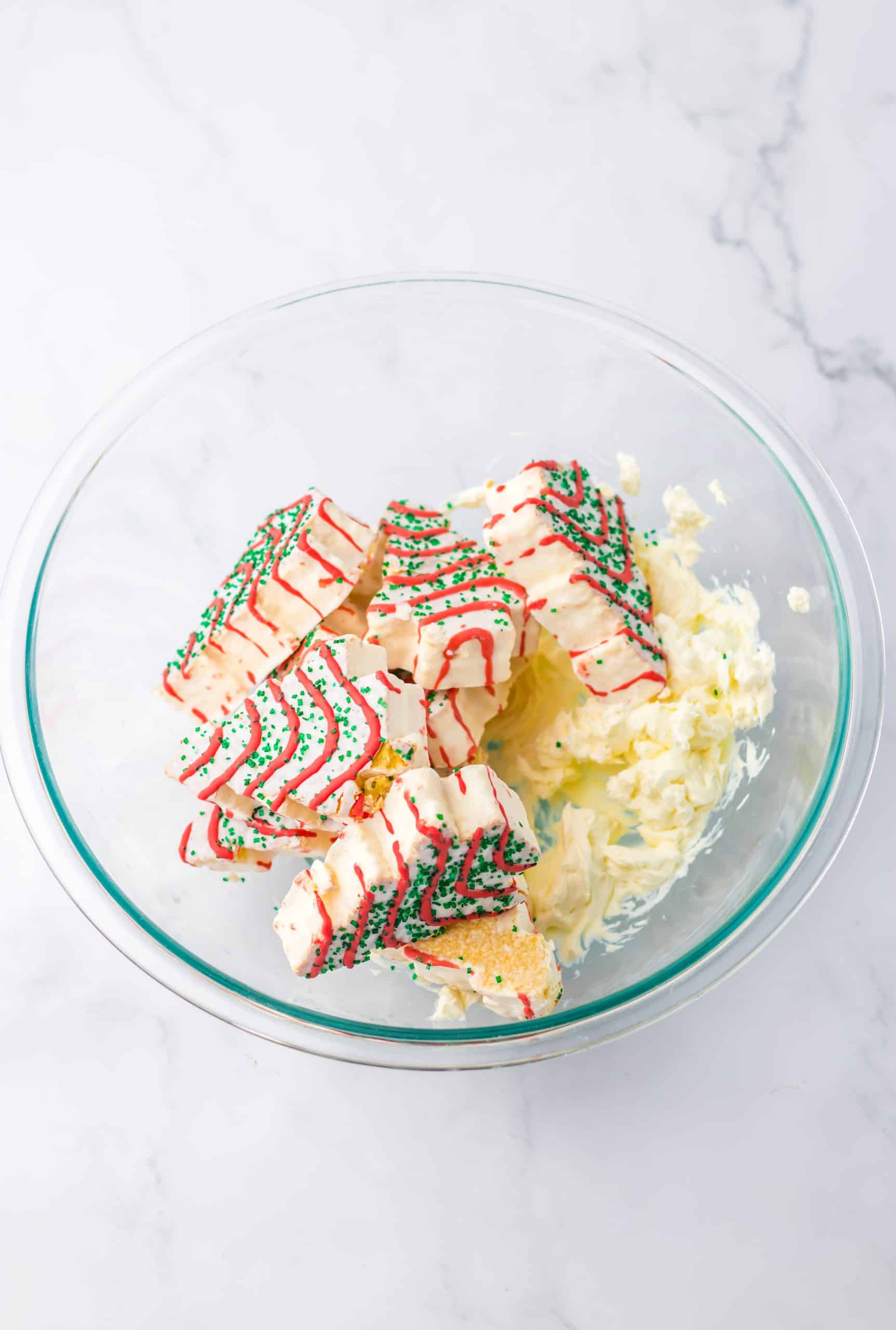 christmas tree cakes and creamed cheese in a glass mixing bowl