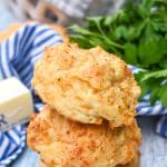 a stack of homemade cheddar bay biscuits on a wooden table