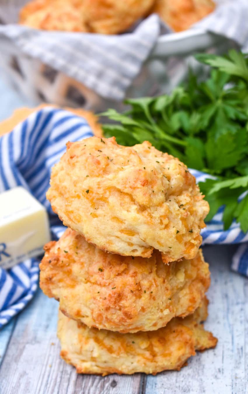 a stack of homemade cheddar bay biscuits on a wooden table