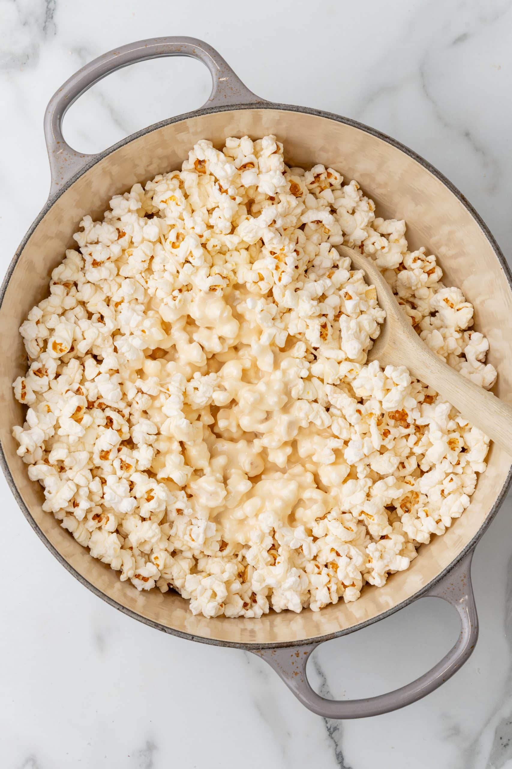 marshmallow sauce poured over popped popcorn in a dutch oven