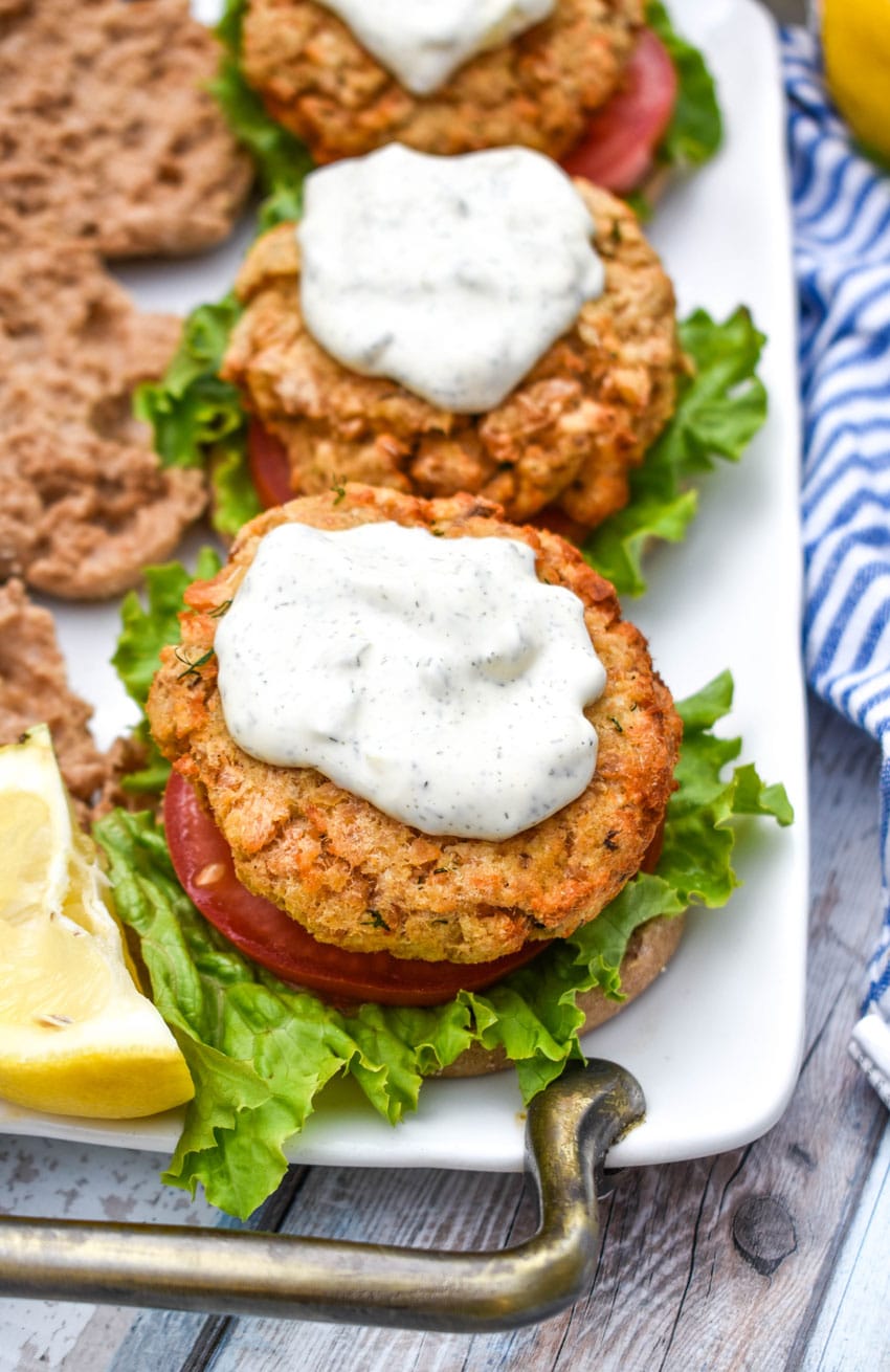 air fryer salmon patties topped with tartar sauce on english muffins with lettuce and tomatoes
