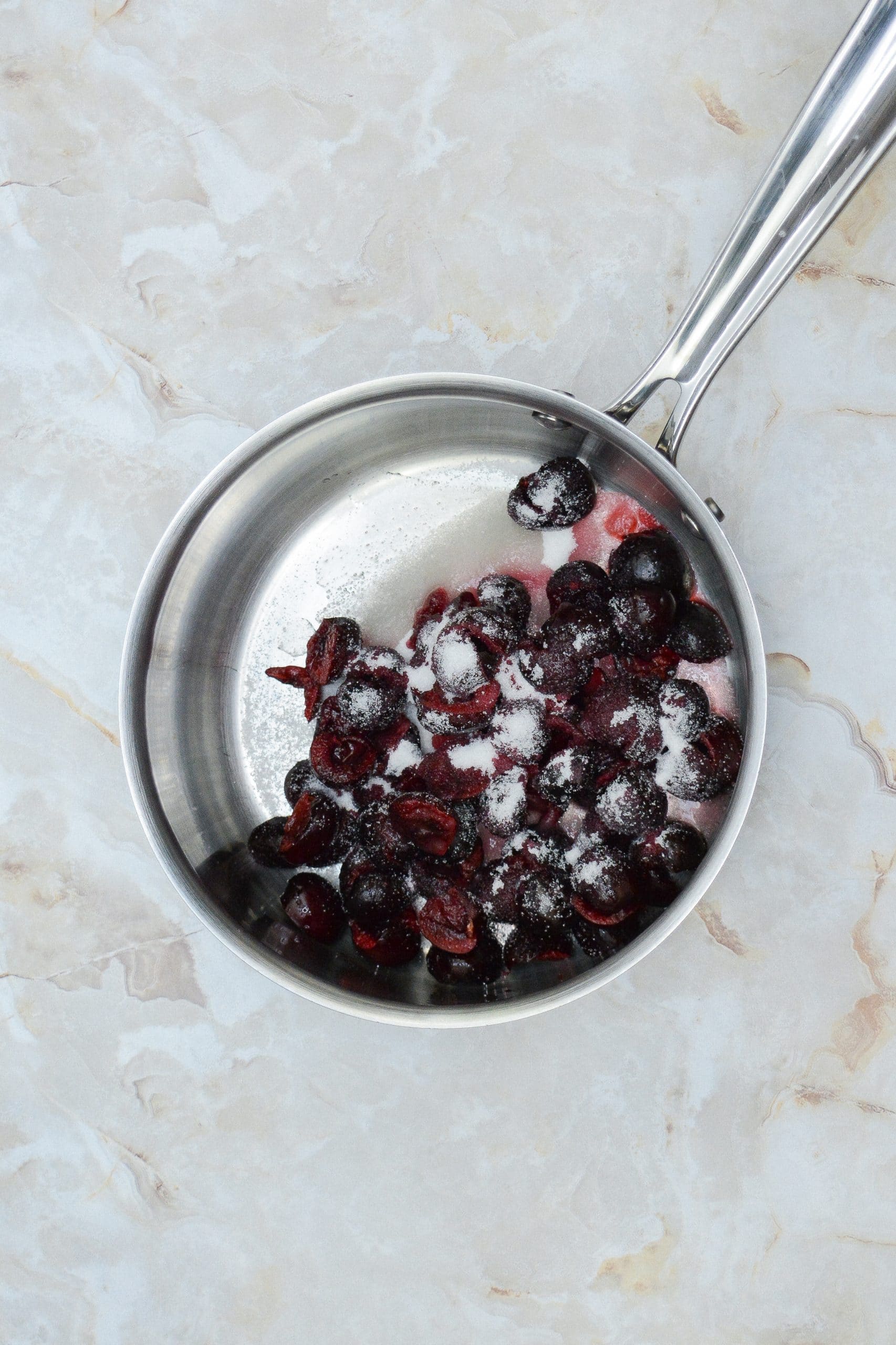 chopped sweet dark cherries and granulated sugar in a metal pot