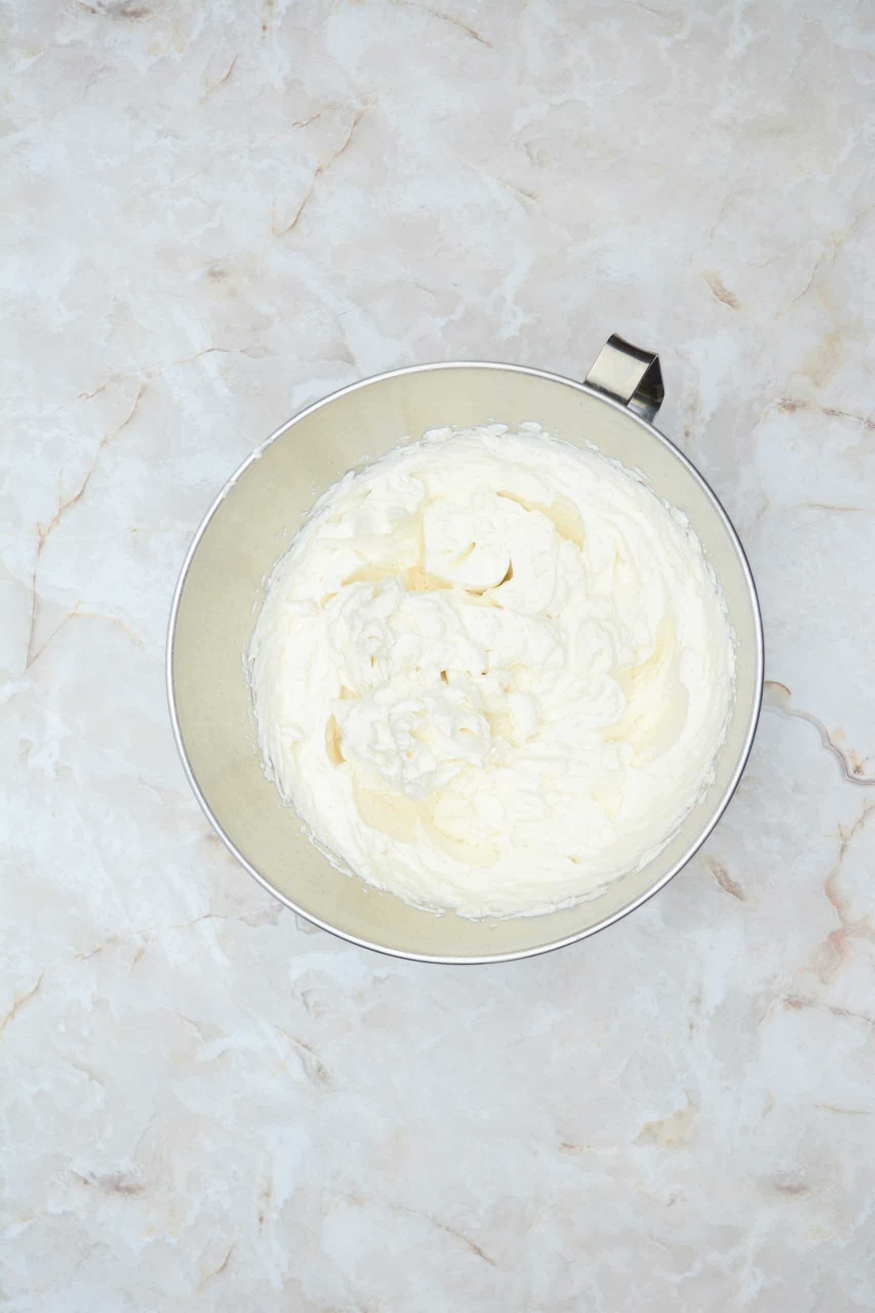 stabilized whipped cream frosting with gelatin in a metal mixing bowl
