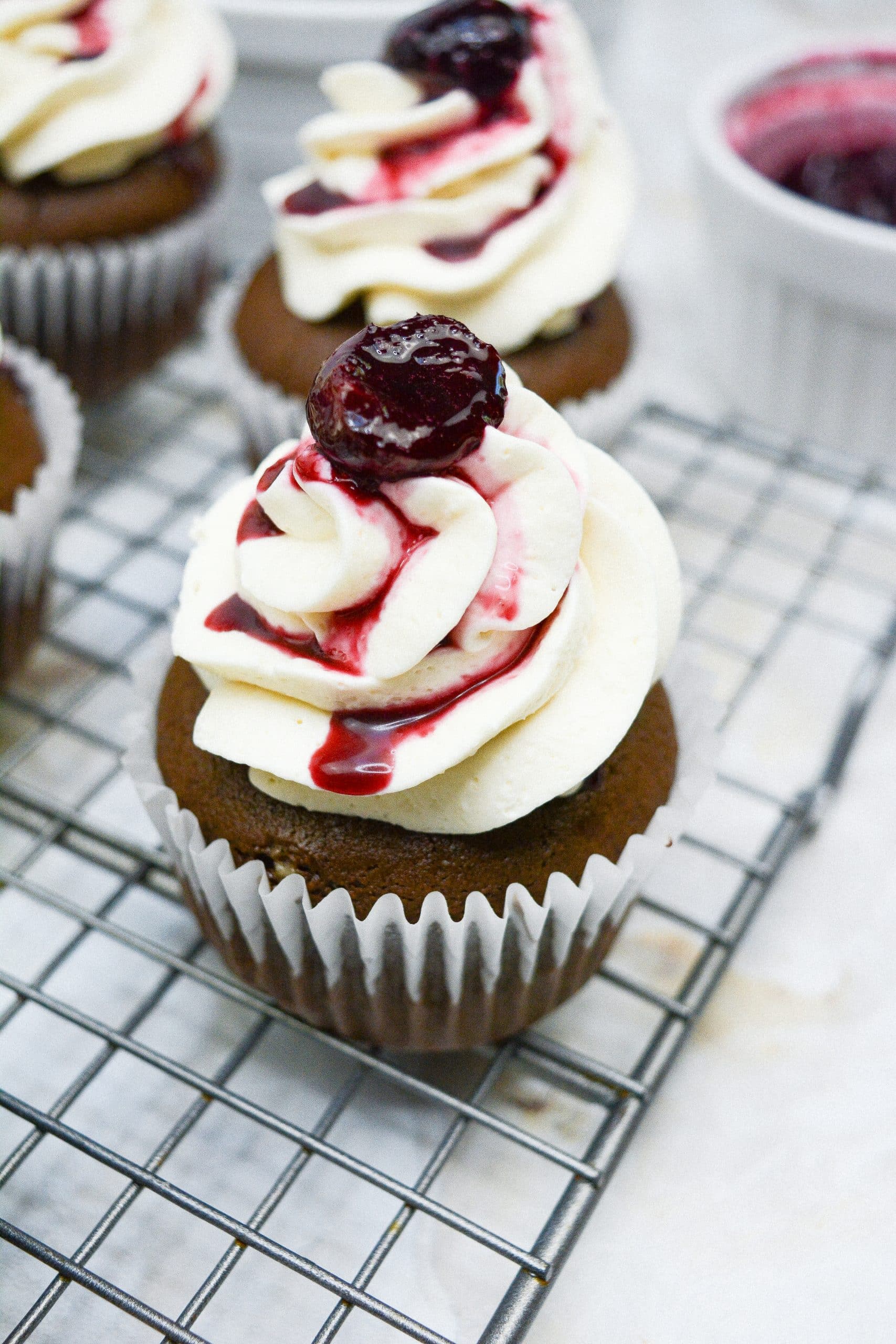 black forest cupcakes on a wire cooling rack