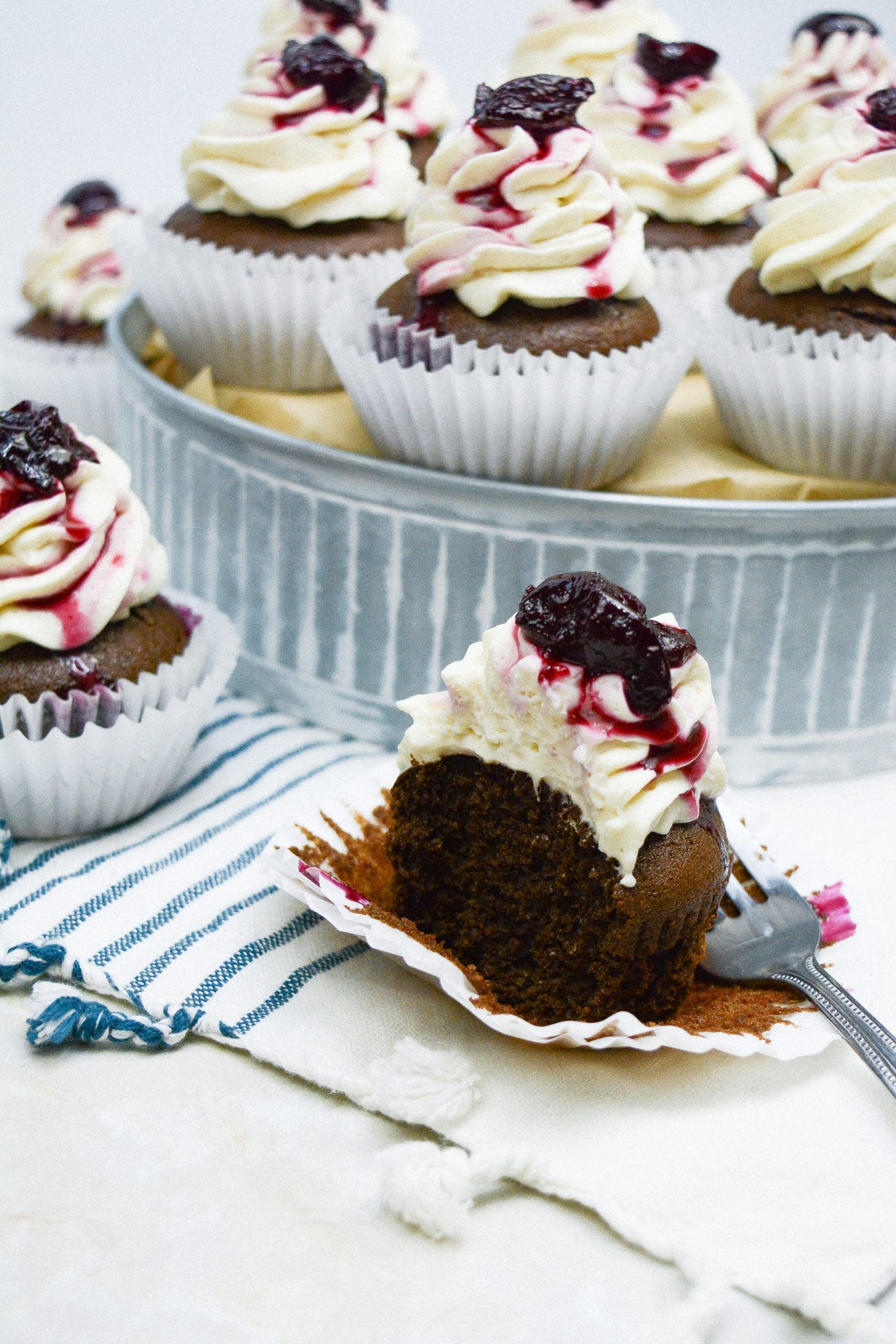 black forest cupcake sitting on a white and blue striped cloth napkin