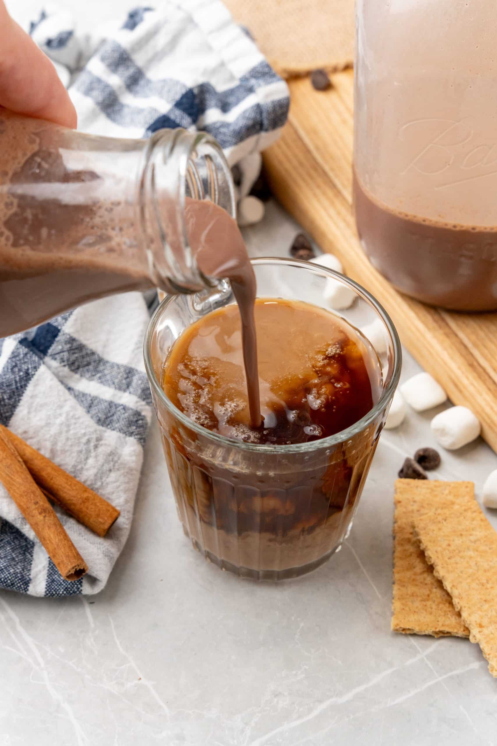 s'mores coffee creamer being poured into black coffee in a glass mug