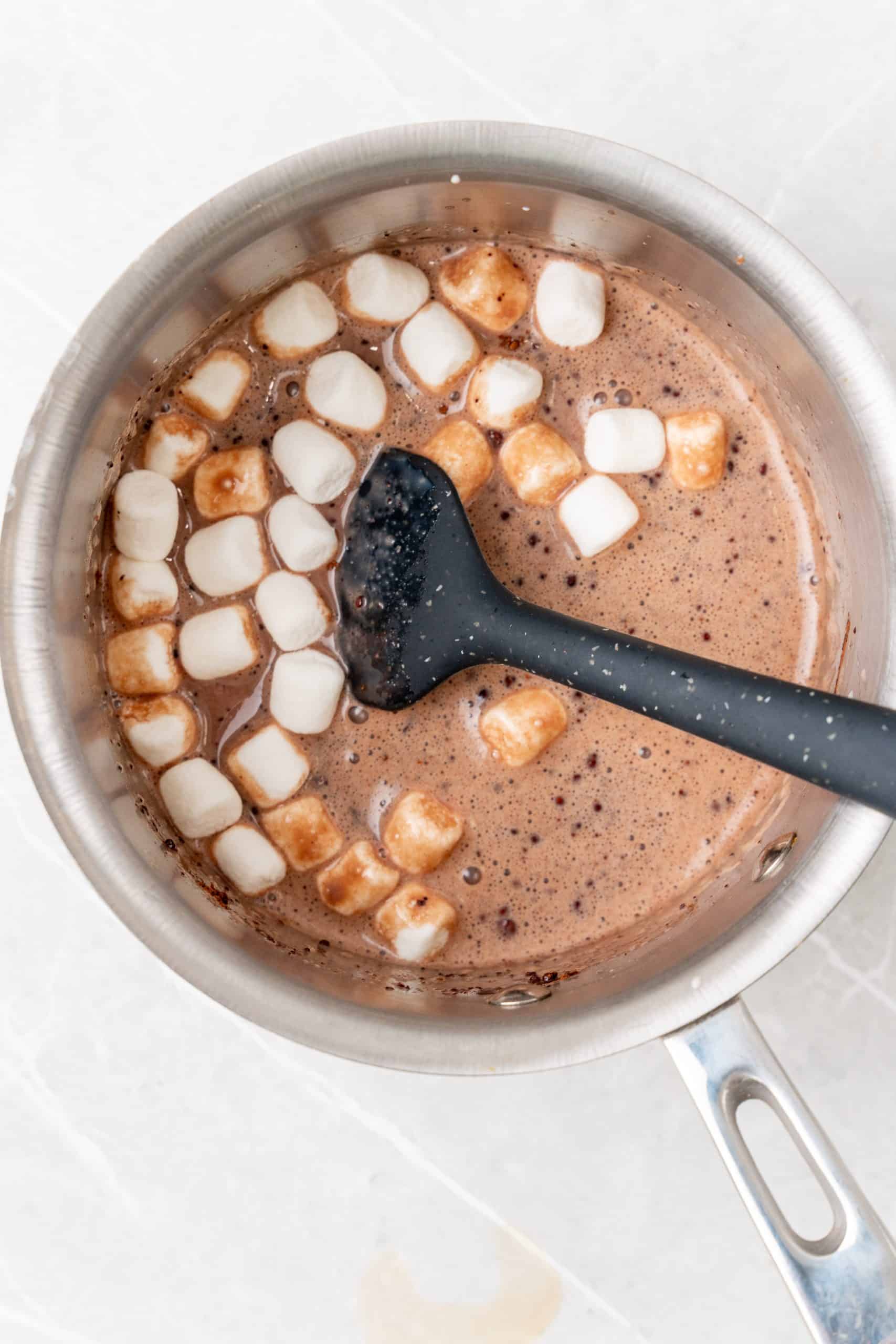 marshmallows in chocolate creamer in a small metal pot