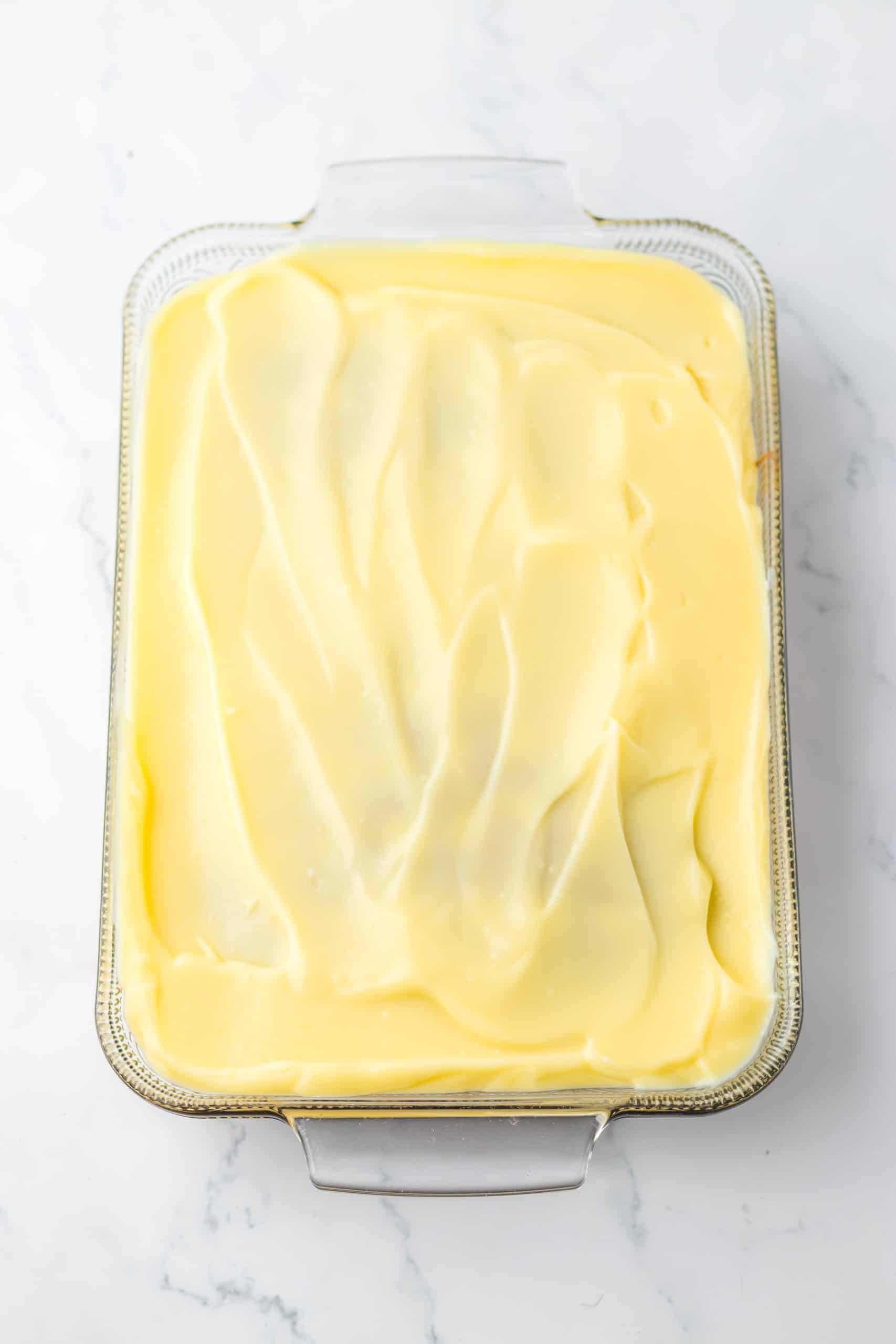 instant vanilla pudding spread out over the top of a baked carrot cake